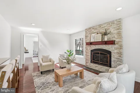 a kitchen with kitchen island wooden floors white appliances and cabinets