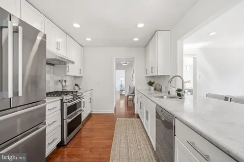 a kitchen with white cabinets and window