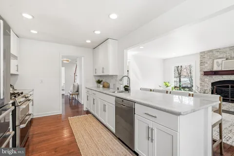 a kitchen with white cabinets and sink