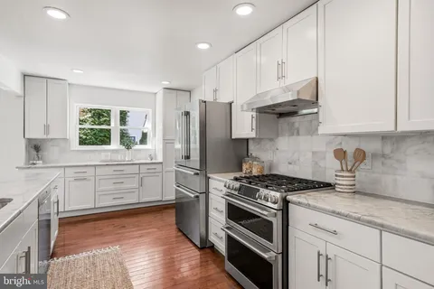 a kitchen with granite countertop white cabinets and a sink