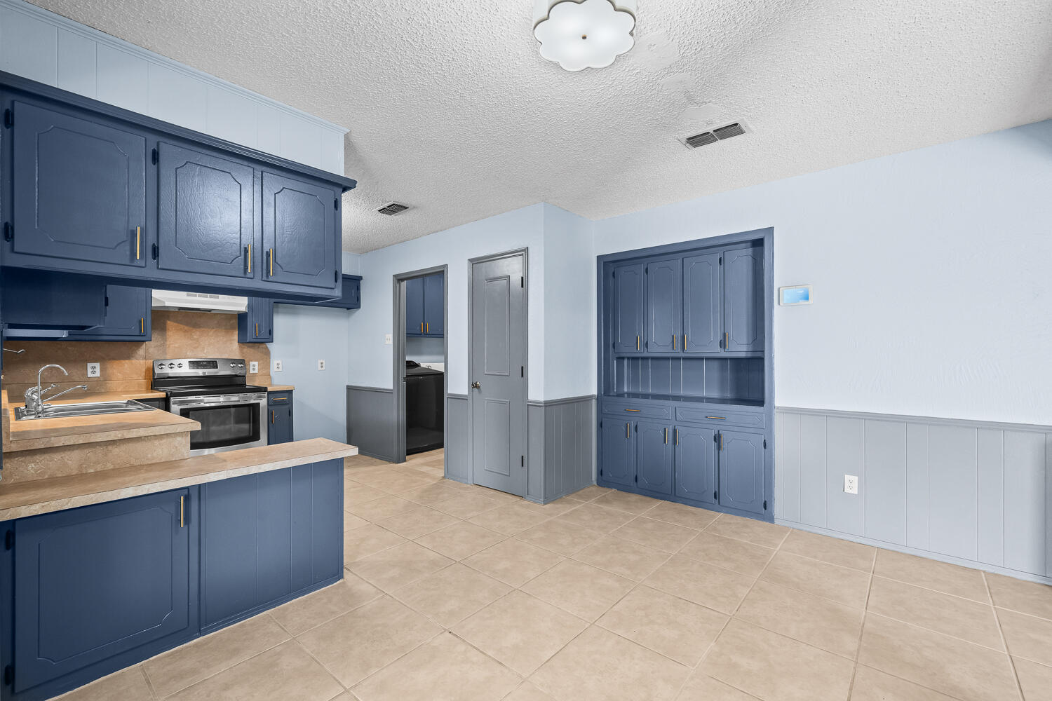 4809 72nd Street Lubbock, TX 79424 - Photo 13 of 34 a kitchen with cabinets and wooden floor