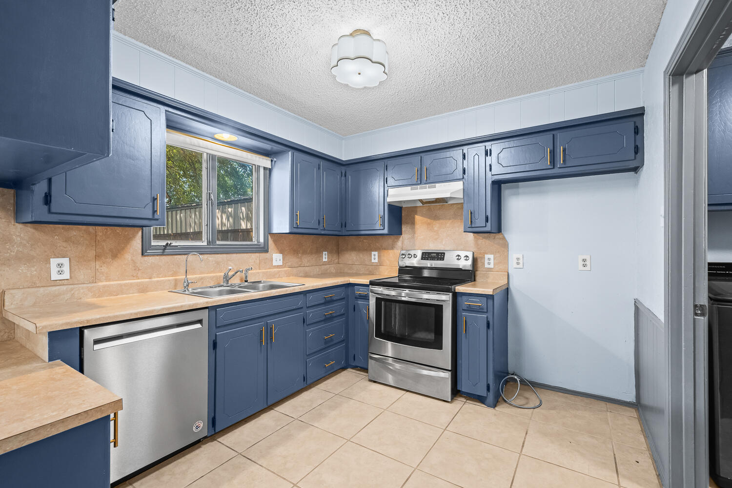4809 72nd Street Lubbock, TX 79424 - Photo 15 of 34 a kitchen with stainless steel appliances granite countertop a stove sink and cabinets
