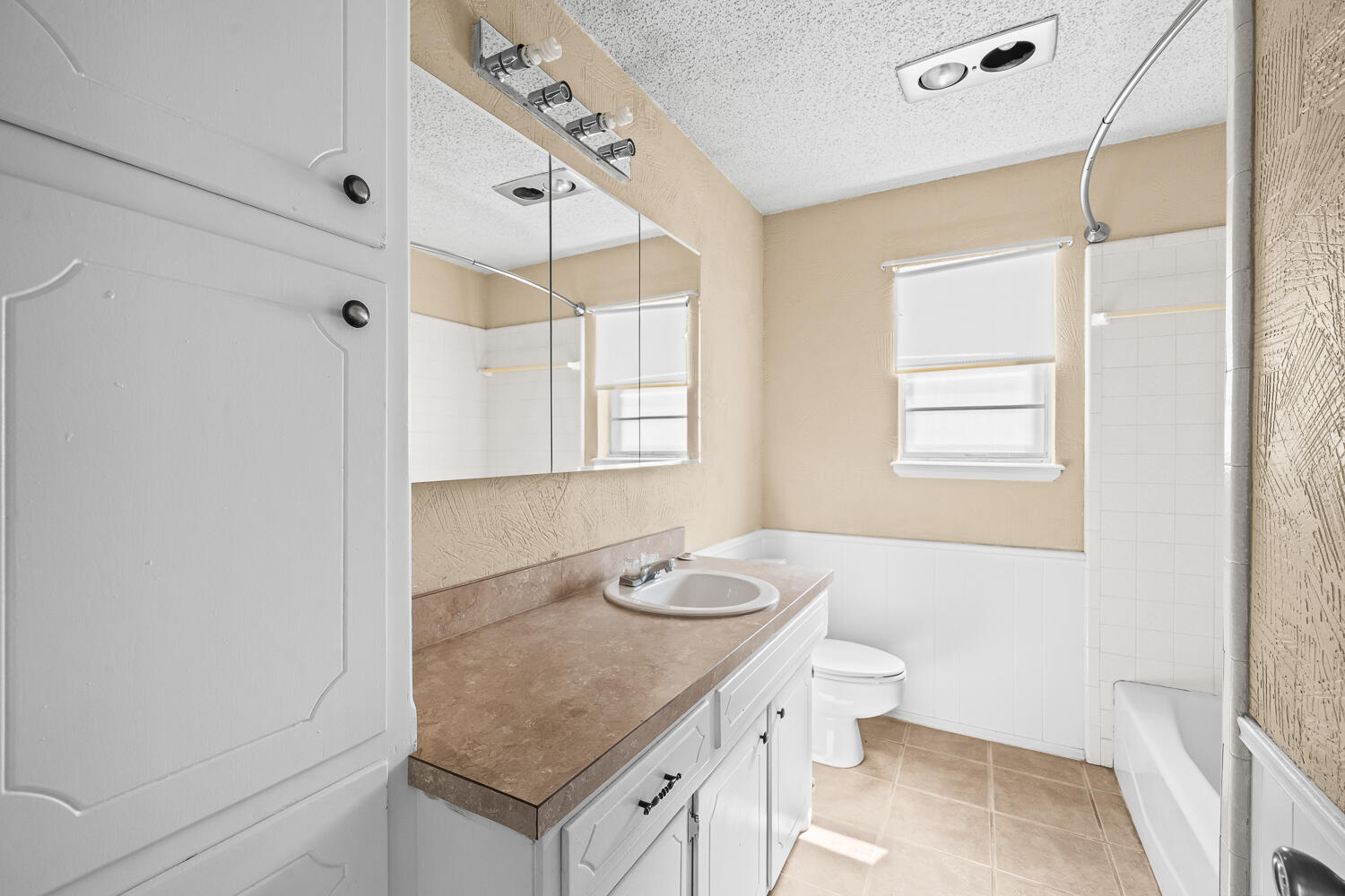 4809 72nd Street Lubbock, TX 79424 - Photo 20 of 34 a bathroom with a granite countertop sink a toilet a mirror and shower