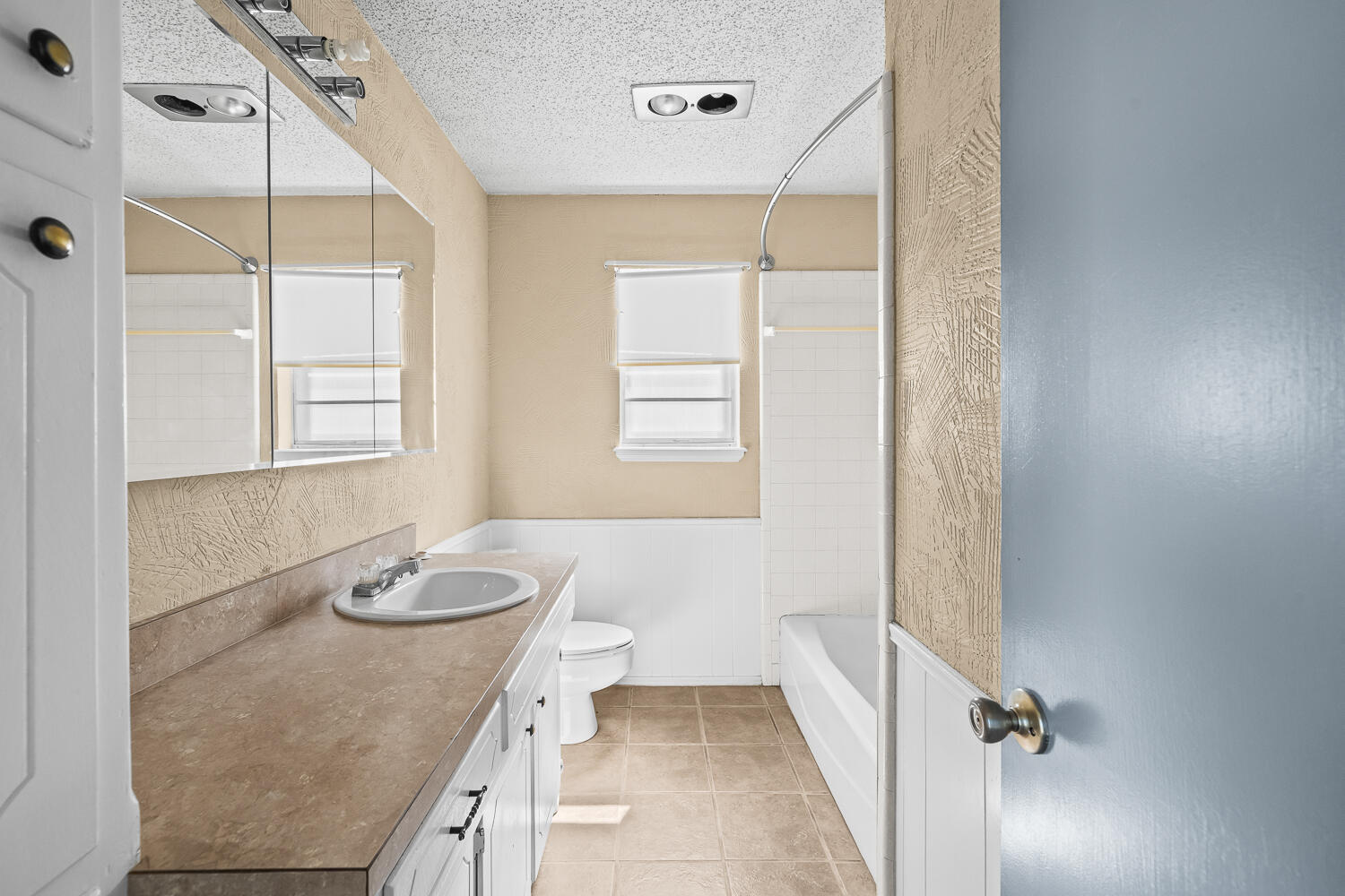 4809 72nd Street Lubbock, TX 79424 - Photo 21 of 34 a bathroom with a granite countertop sink a mirror and a bathtub