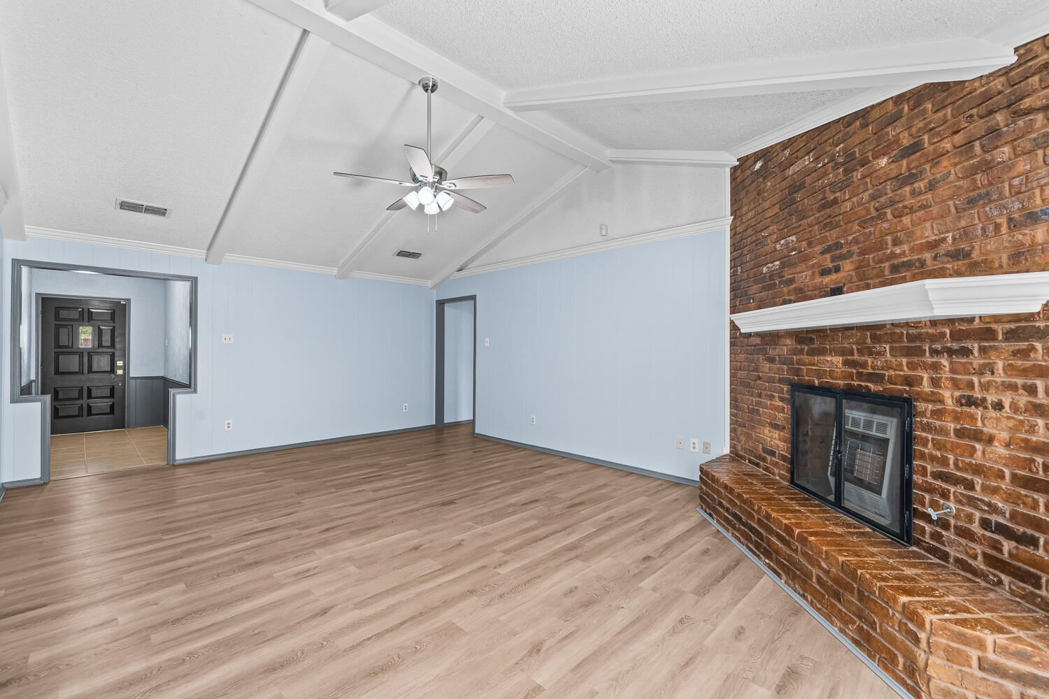 4809 72nd Street Lubbock, TX 79424 - Photo 6 of 34 a view of an empty room with wooden floor fireplace and a window