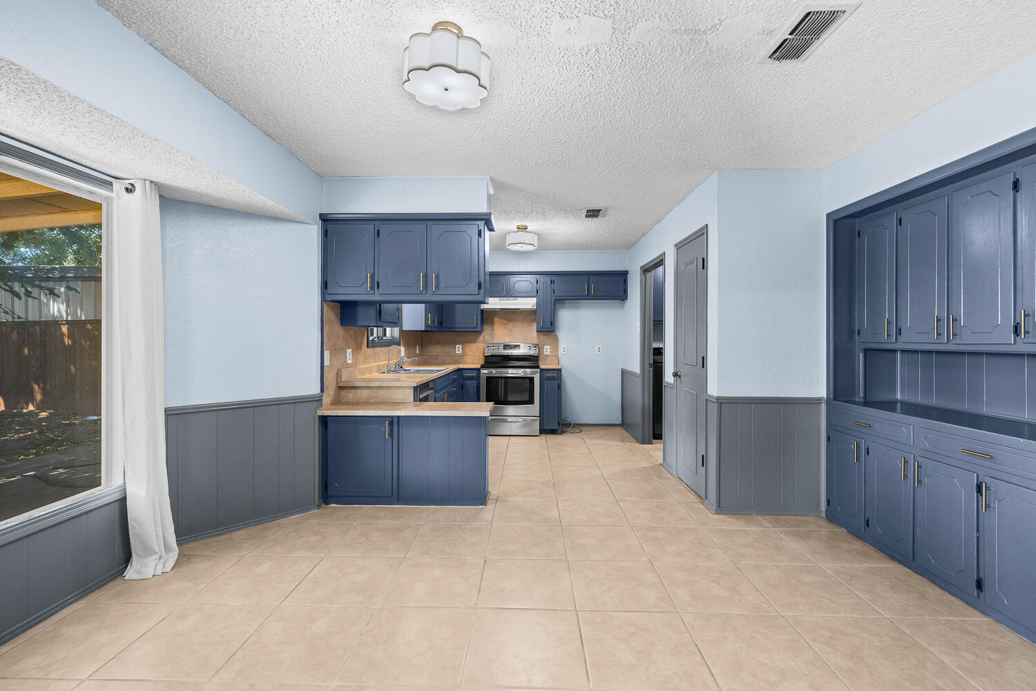 4809 72nd Street Lubbock, TX 79424 - Photo 8 of 34 a large kitchen with cabinets and stainless steel appliances