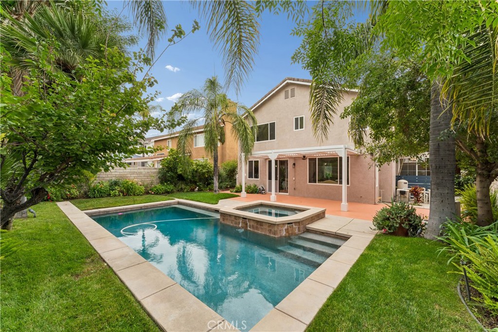 26023 Salinger Lane Stevenson Ranch, CA 91381 - Photo 29 of 35 Stunning backyard retreat complete with a sparkling pool, relaxing spa, lush palm trees, and fruit trees.