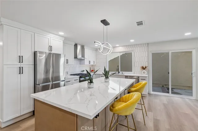 a kitchen with a table chairs and refrigerator