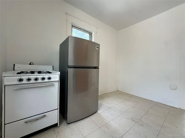 a white refrigerator freezer and a stove sitting inside of a kitchen