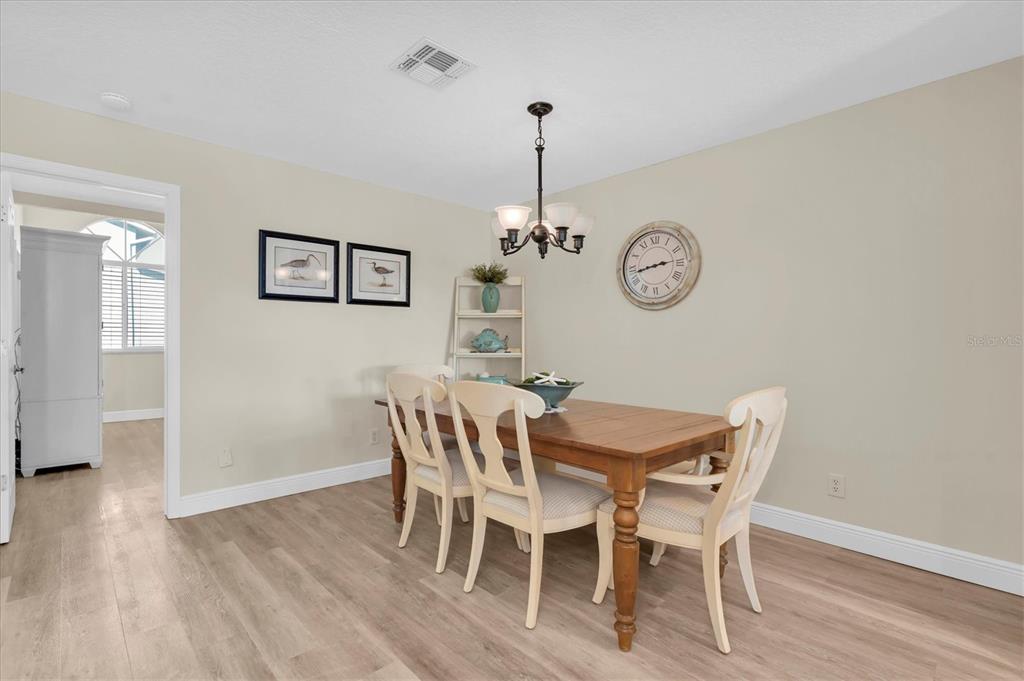 641 Garland Circle Indian Rocks Beach, FL 33785 - Photo 15 of 50 a view of a dining room with furniture wooden floor and a chandelier