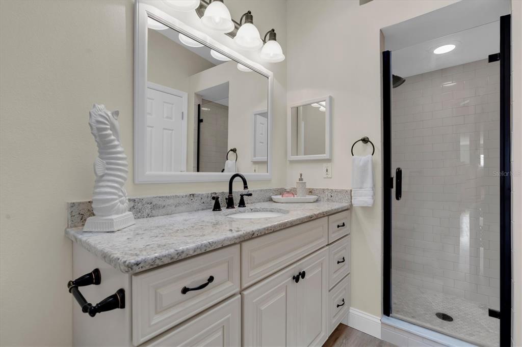 641 Garland Circle Indian Rocks Beach, FL 33785 - Photo 19 of 50 a bathroom with a granite countertop sink and a mirror