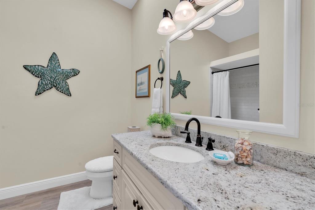 641 Garland Circle Indian Rocks Beach, FL 33785 - Photo 23 of 50 a bathroom with a sink a toilet and a mirror