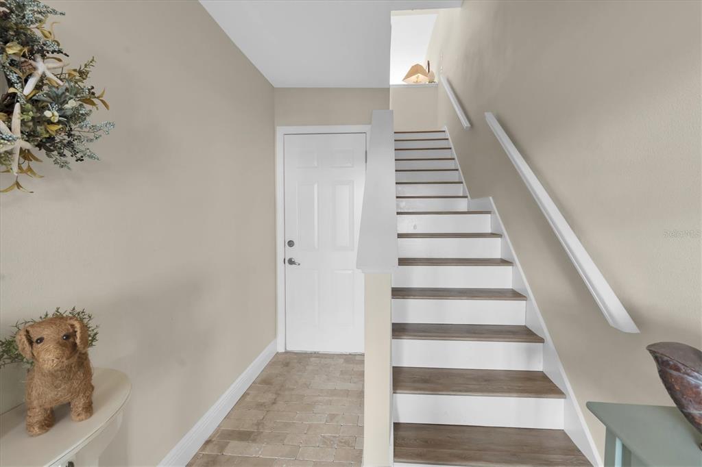 641 Garland Circle Indian Rocks Beach, FL 33785 - Photo 8 of 50 a view of staircase with white walls and a potted plant