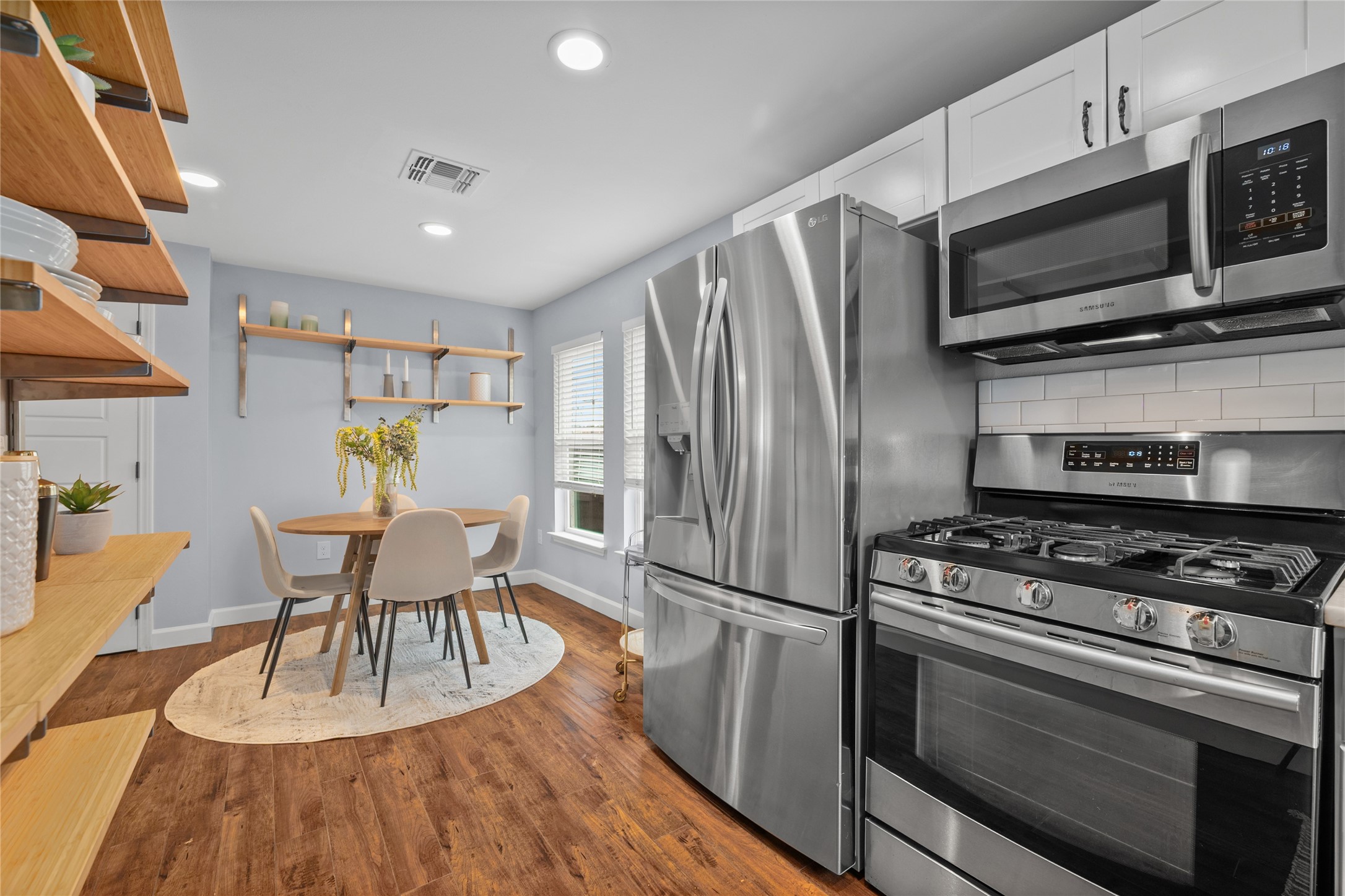 1191 Chicon Street Austin, TX 78702 - Photo 12 of 33 a kitchen with stainless steel appliances a stove a microwave a dining table and chairs