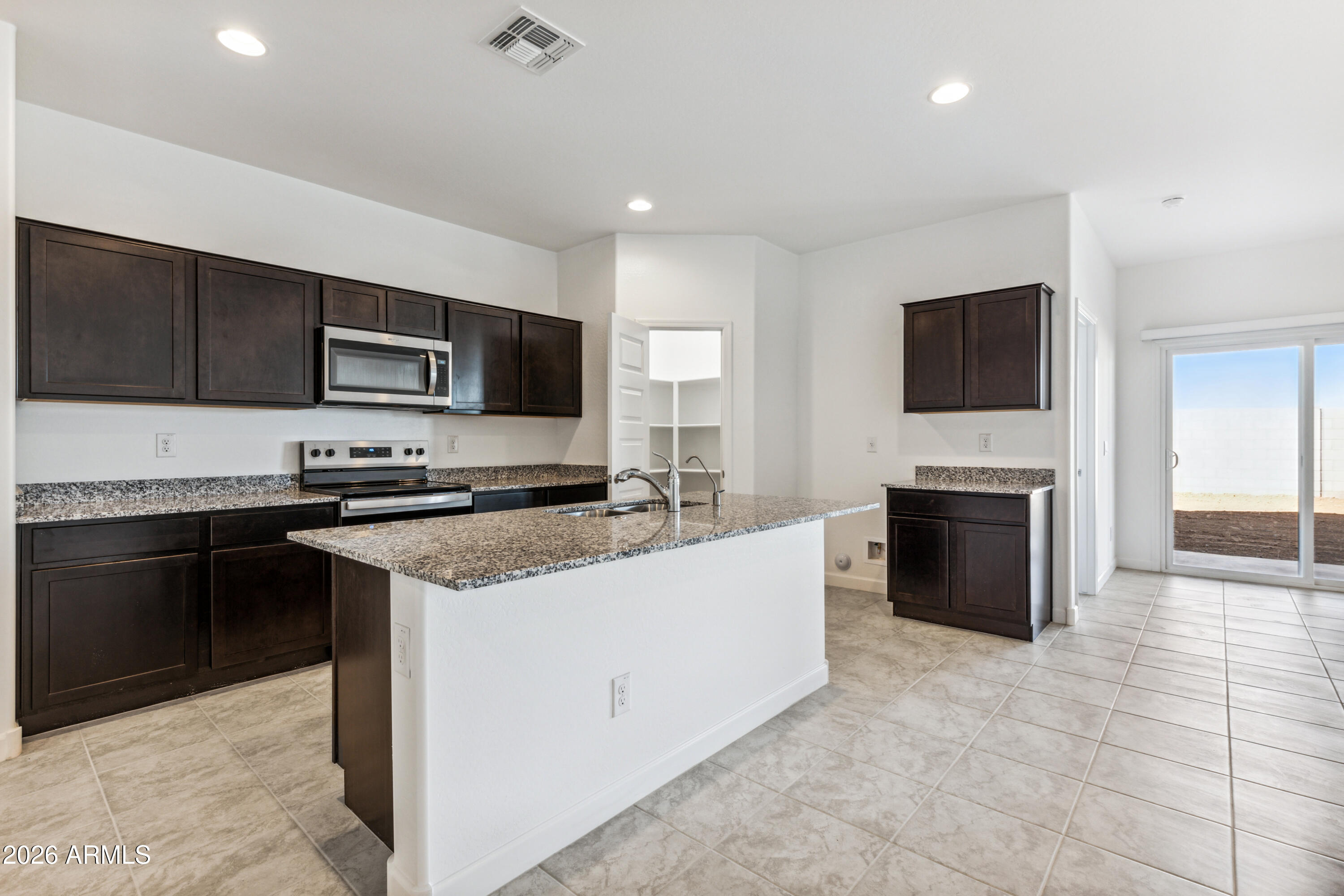 17885 North Ravello Road Maricopa, AZ 85138 - Photo 10 of 35 a kitchen with a stove a sink and a microwave