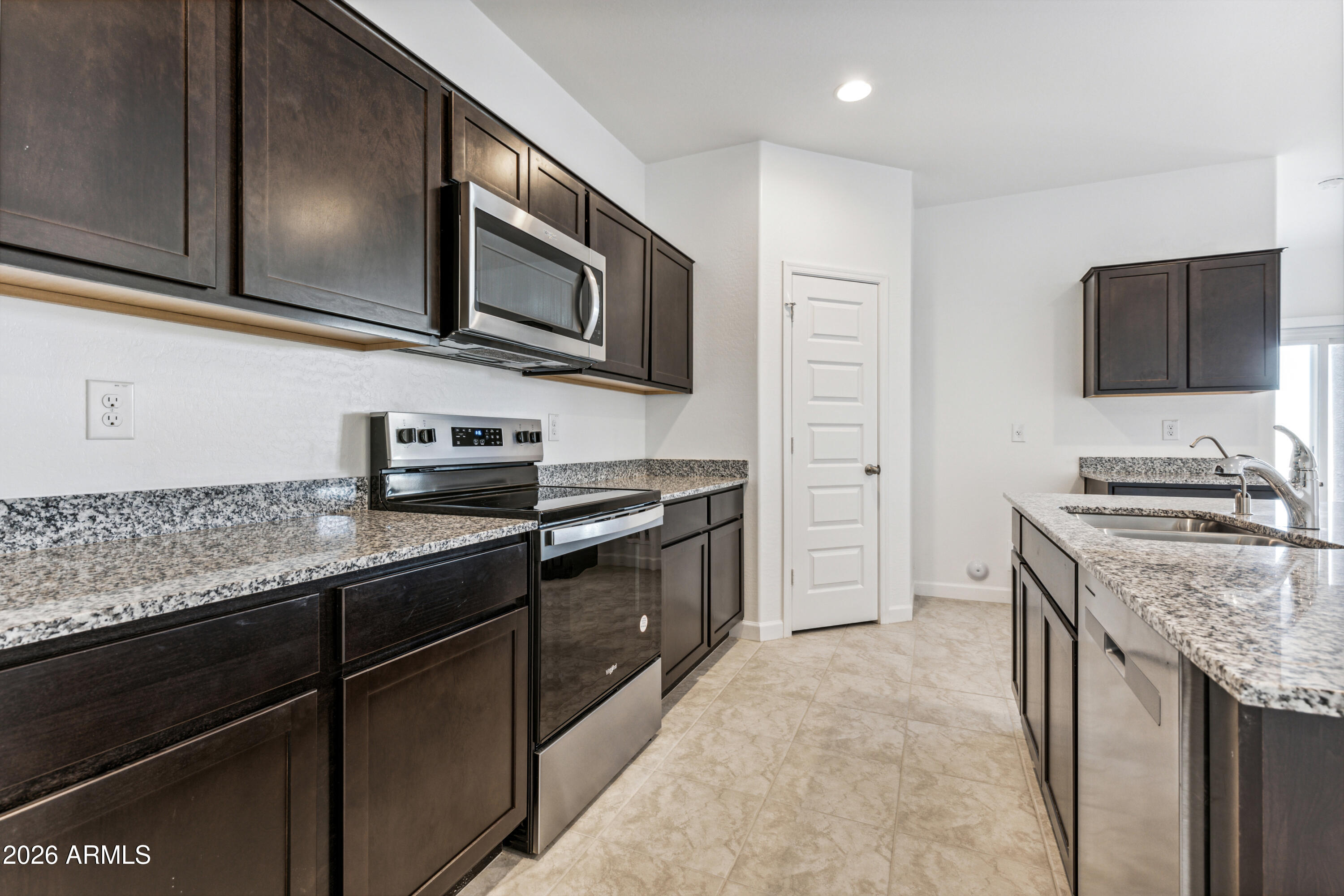 17885 North Ravello Road Maricopa, AZ 85138 - Photo 6 of 35 a kitchen with stainless steel appliances granite countertop a sink stove and microwave