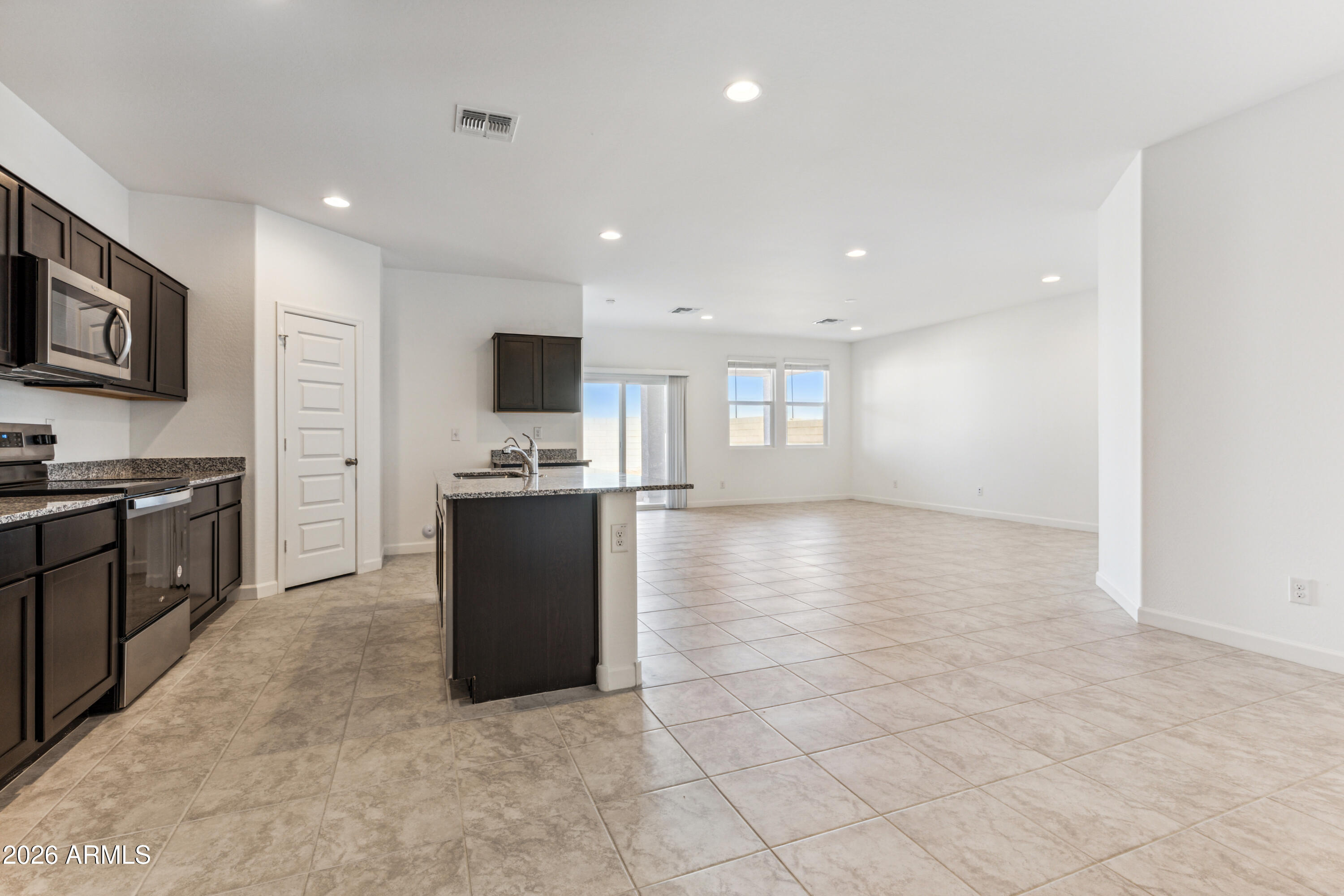 17885 North Ravello Road Maricopa, AZ 85138 - Photo 7 of 35 a kitchen with stainless steel appliances granite countertop a refrigerator and a stove top oven