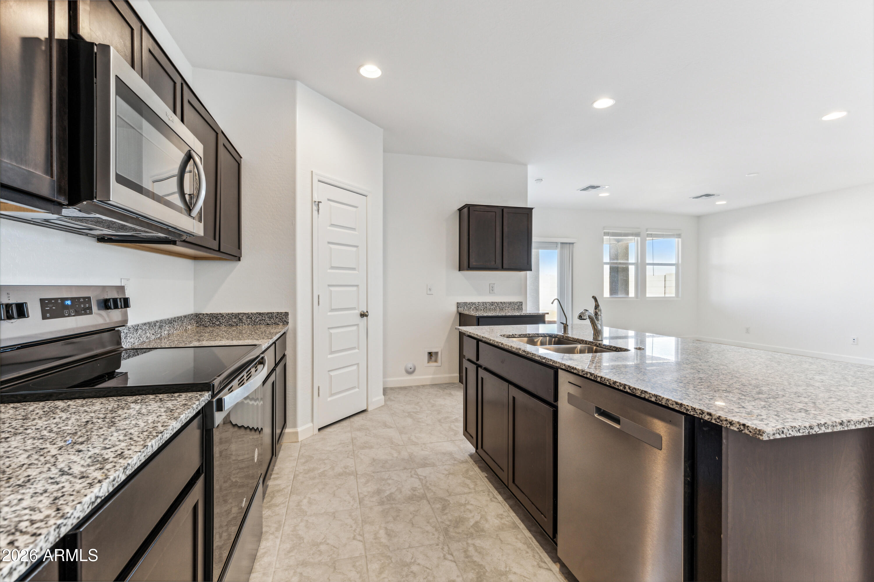 17885 North Ravello Road Maricopa, AZ 85138 - Photo 8 of 35 a kitchen with stainless steel appliances granite countertop a sink stove and refrigerator