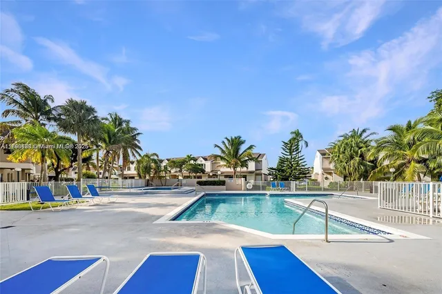 a view of a swimming pool with a lawn chairs under an umbrella