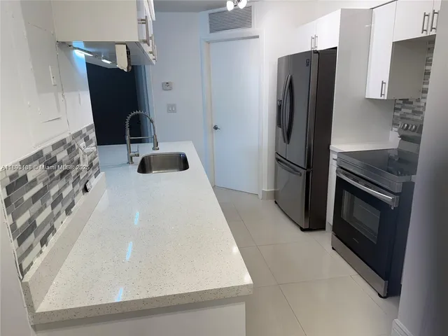 a kitchen with stainless steel appliances granite countertop a refrigerator and a stove