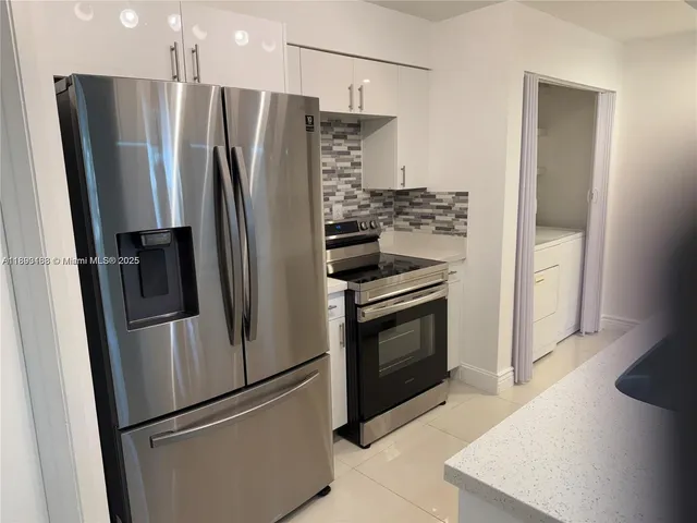 a metallic refrigerator freezer sitting in a kitchen
