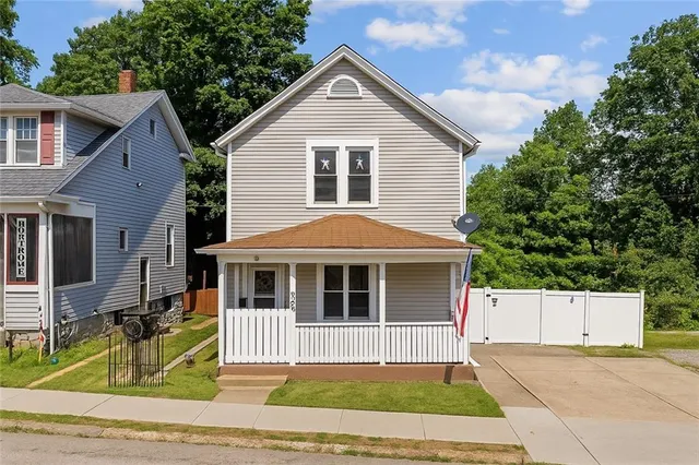 a front view of a house with a garden and yard