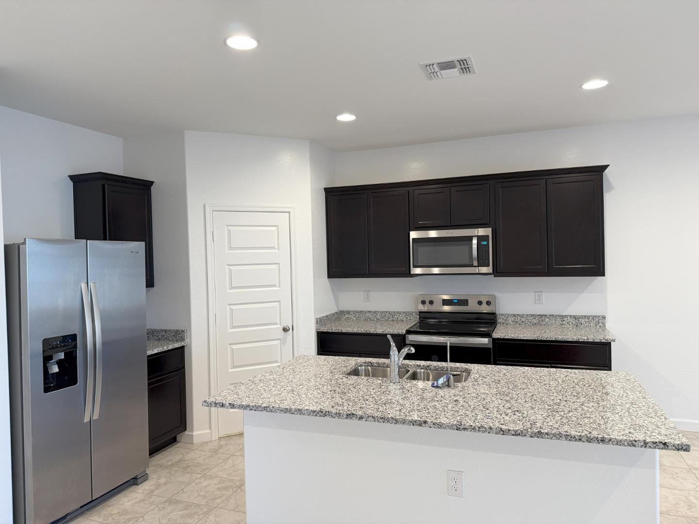 1840 West Spaulding Avenue Apache Junction, AZ 85120 - Photo 12 of 53 a kitchen with stainless steel appliances granite countertop a sink and a refrigerator