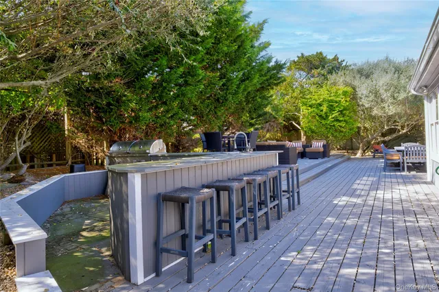a view of a patio with table and chairs with wooden floor and fence