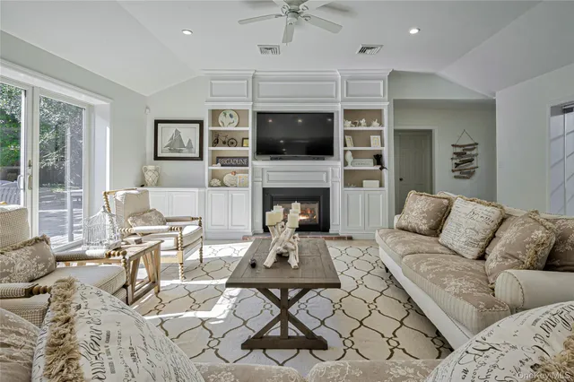 a living room with furniture a flat screen tv and a fireplace