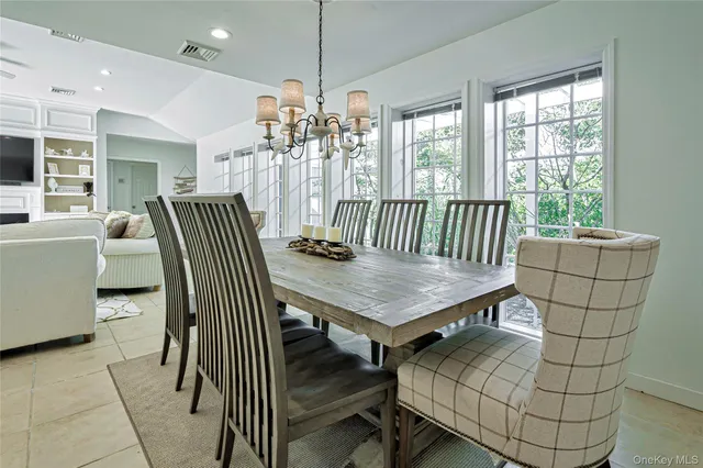 a dining room with furniture a chandelier and window