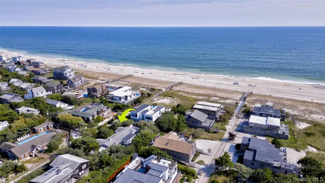 an aerial view of residential houses with outdoor space and ocean view