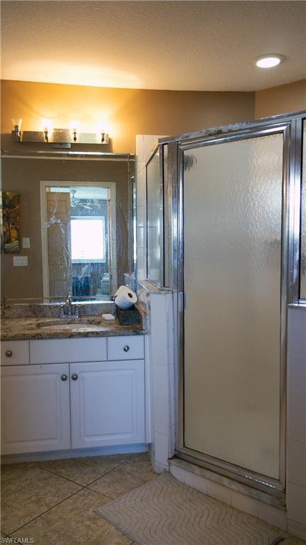 9061 Michael Circle, Unit 2 Naples, FL 34113 - Photo 39 of 48 Bathroom with a shower with door, tasteful backsplash, and large vanity