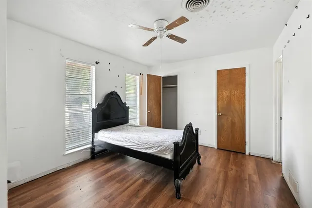 a bedroom with a bed and wooden floor