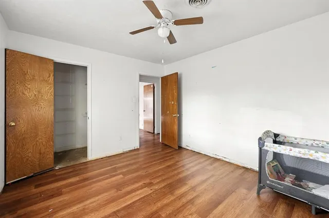 a view of an empty room with wooden floor