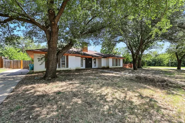 a view of a house with a tree in front of it
