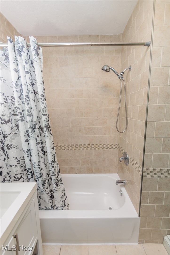 3181 Warren Road Cleveland, OH 44111 - Photo 12 of 28 Bathroom with vanity, tile patterned floors, and shower / tub combo