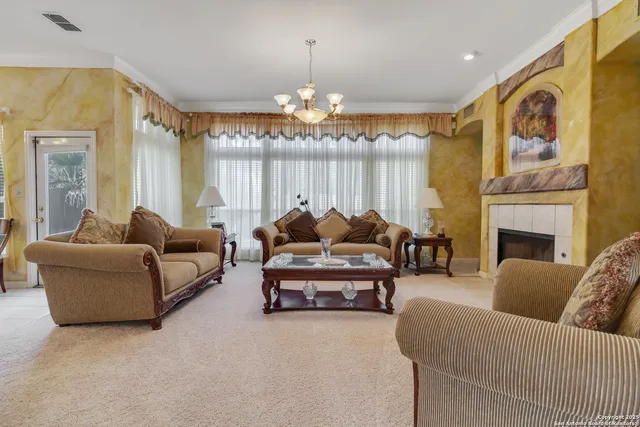 a living room with furniture a chandelier and a fireplace