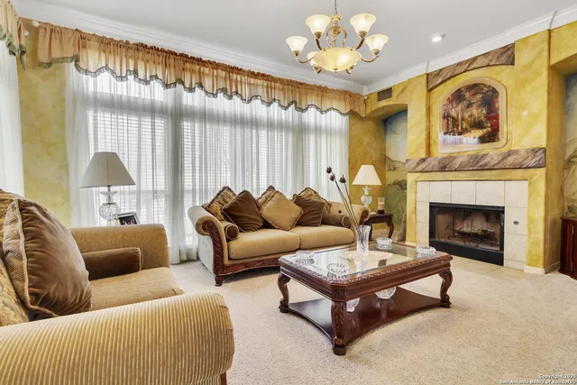 a living room with furniture a chandelier and a fireplace