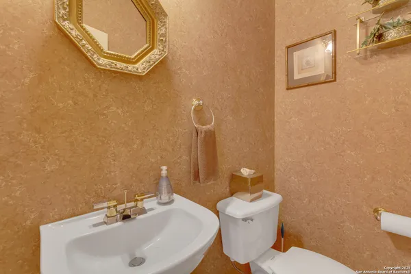 a bathroom with a sink mirror and toilet