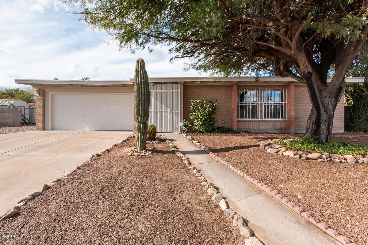 7761 North Rasmussen Avenue Tucson, AZ 85741 - Photo 1 of 23 a front view of a house with a yard and potted plants