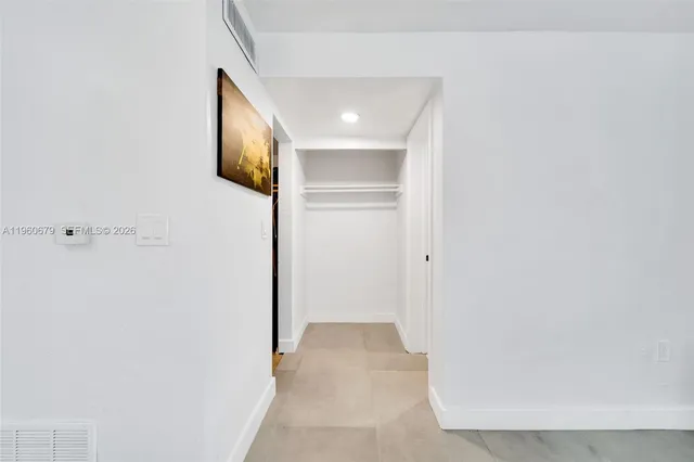 a view of a hallway with wooden floor and closet