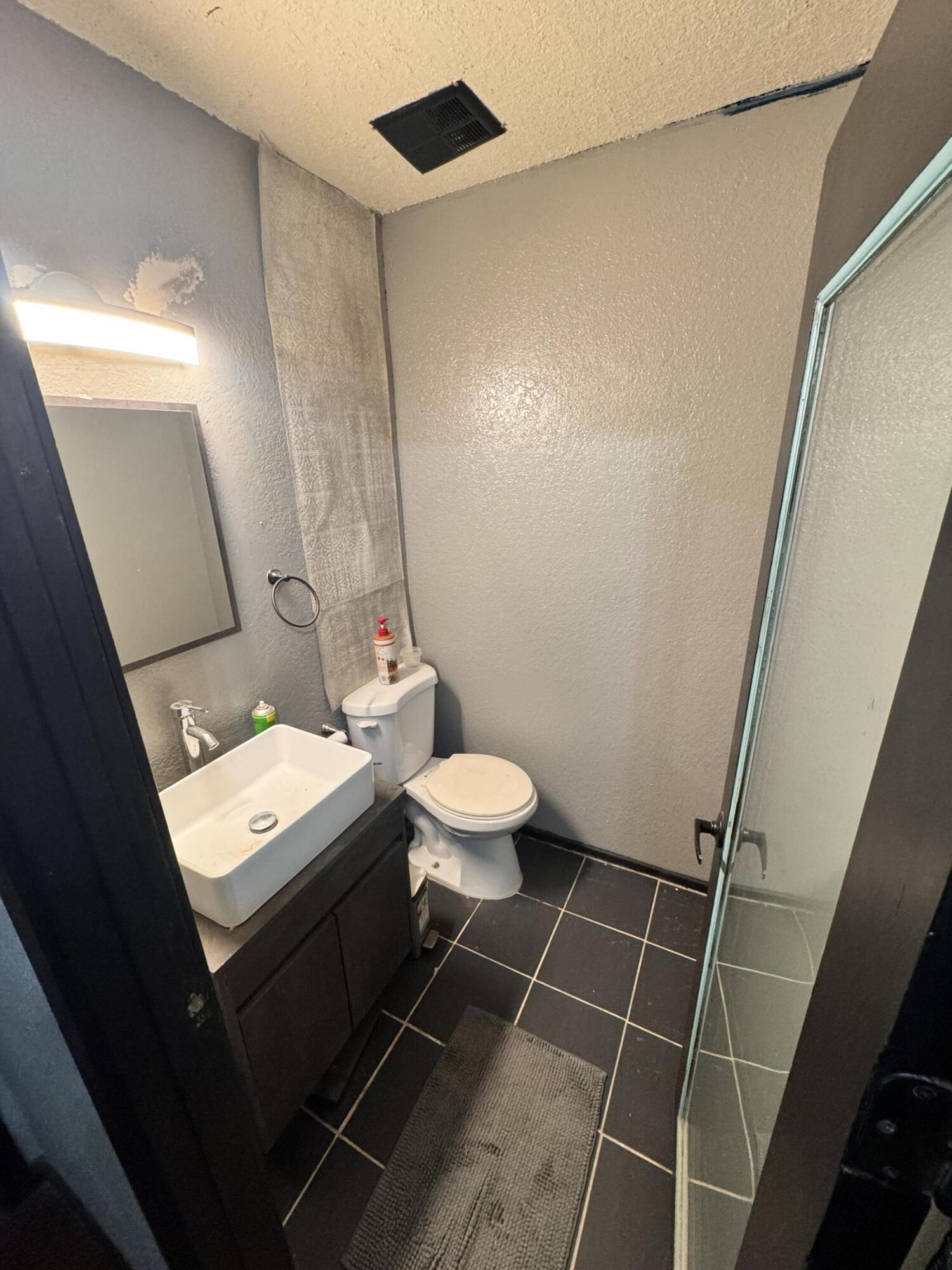 302 East 15th Street Wolfforth, TX 79382 - Photo 8 of 13 a bathroom with a toilet a sink and a mirror