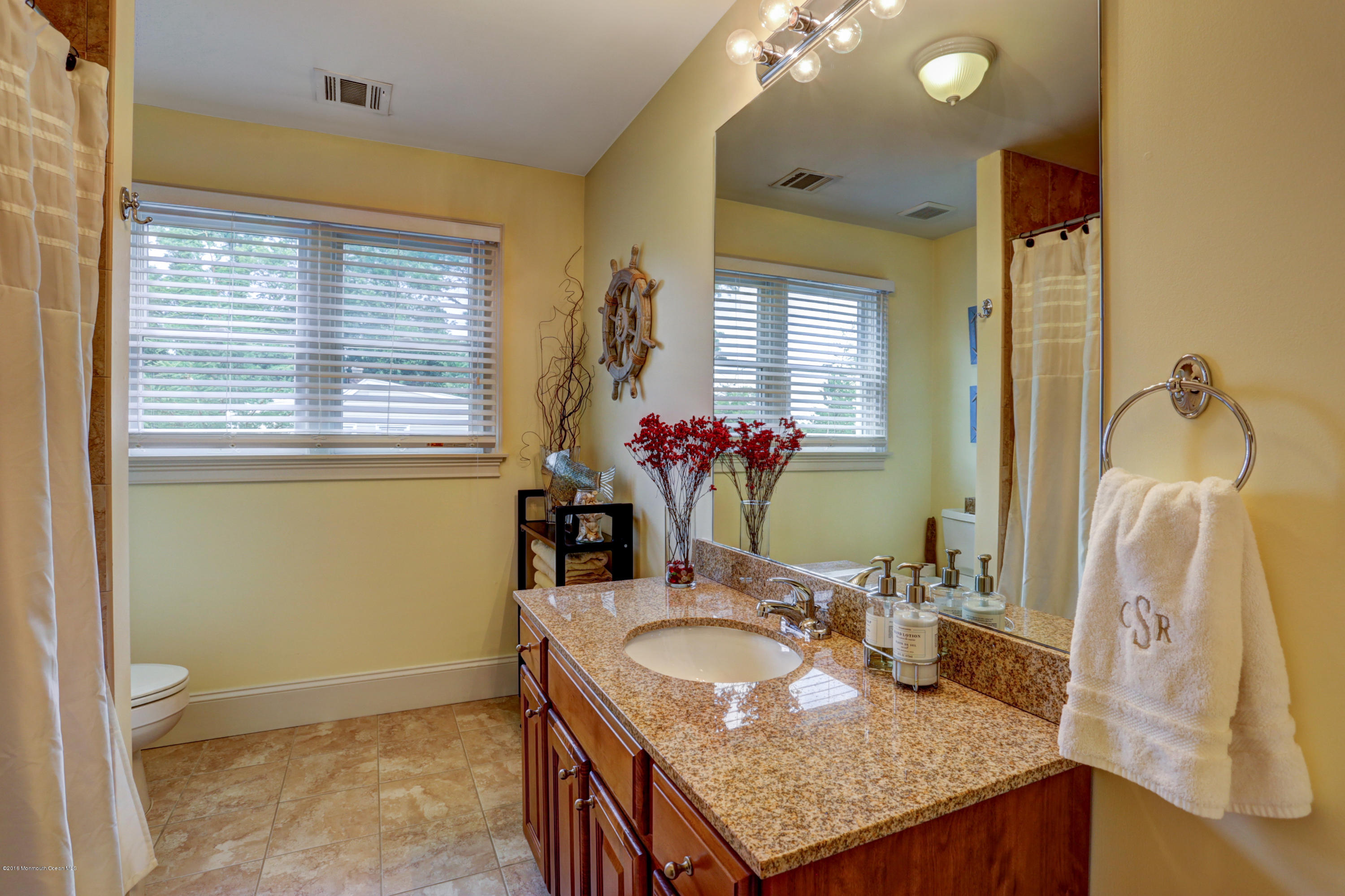 434 E Road Middletown, NJ 07718 - Photo 23 of 30 a bathroom with a granite countertop sink and a mirror