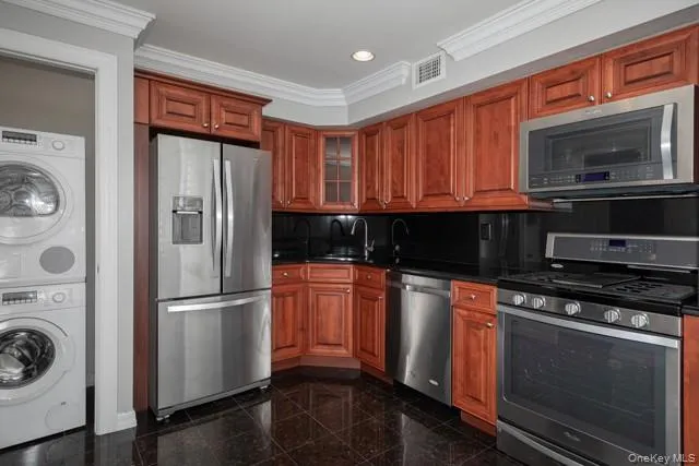 a kitchen with granite countertop a refrigerator stove and microwave