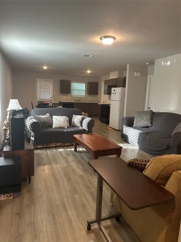 a living room with furniture and wooden floor