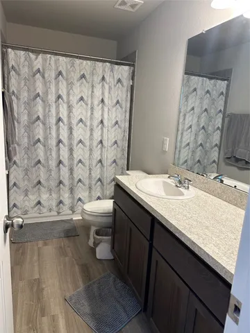 a bathroom with a granite countertop sink toilet and a mirror