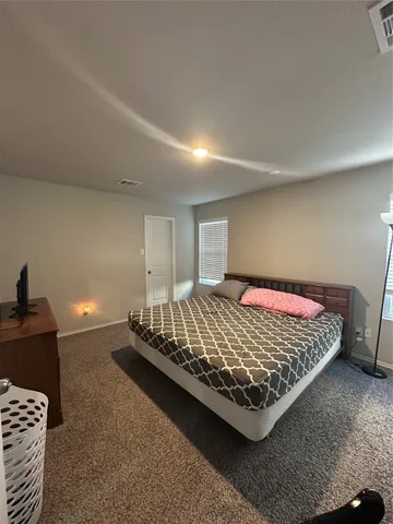 a bed sitting in a room next to a lamp
