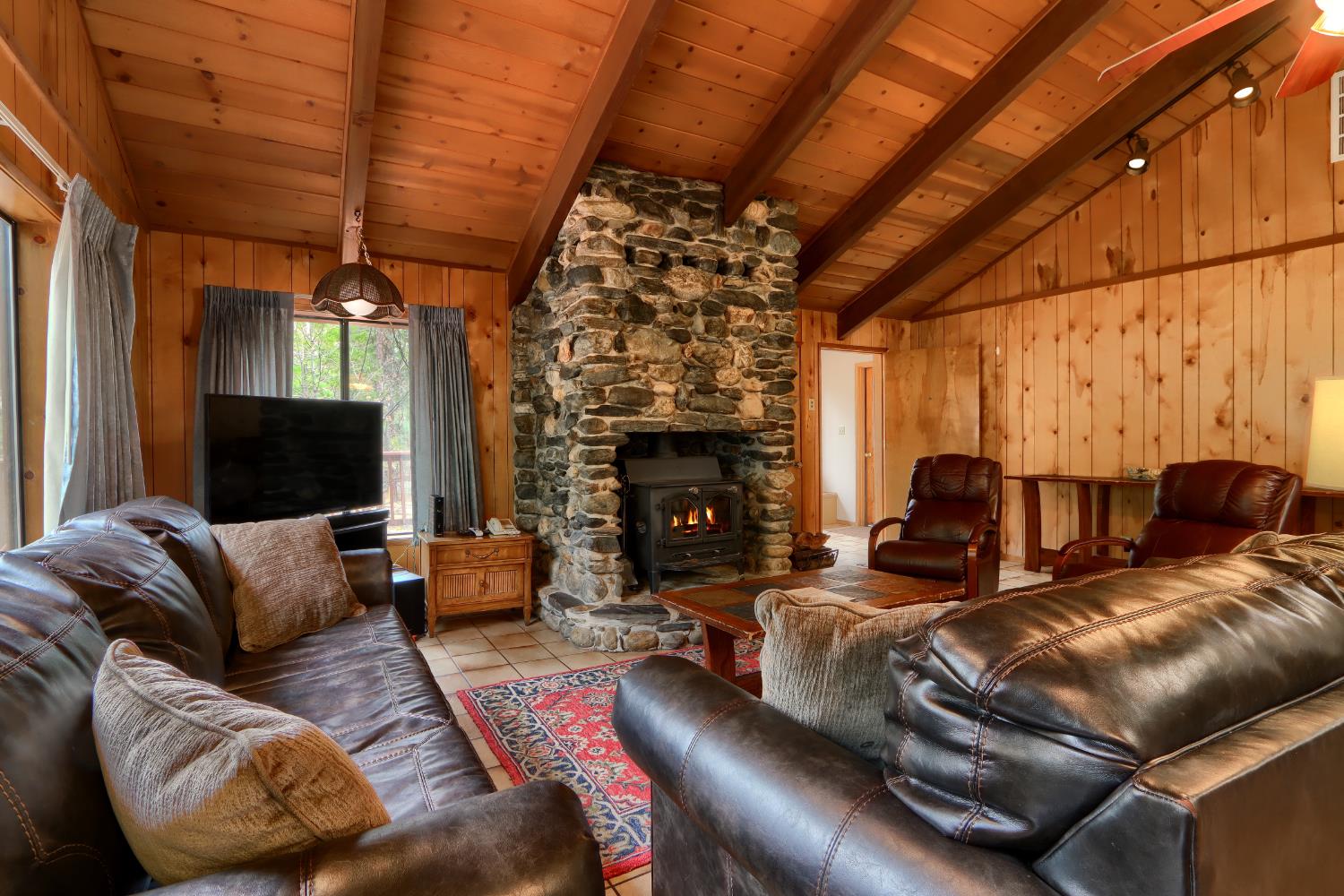 8041 Chilnualna Falls Road Wawona, CA 95389 - Photo 4 of 46 a living room with furniture a fireplace and a flat screen tv