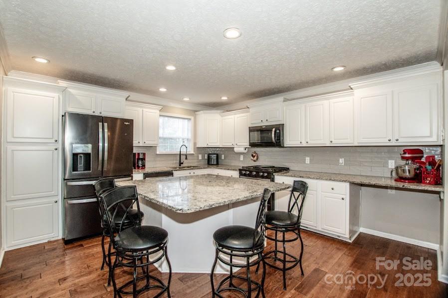 224 Stewart Rock Road Stony Point, NC 28678 - Photo 14 of 41 a kitchen with stainless steel appliances granite countertop a table chairs sink refrigerator and microwave