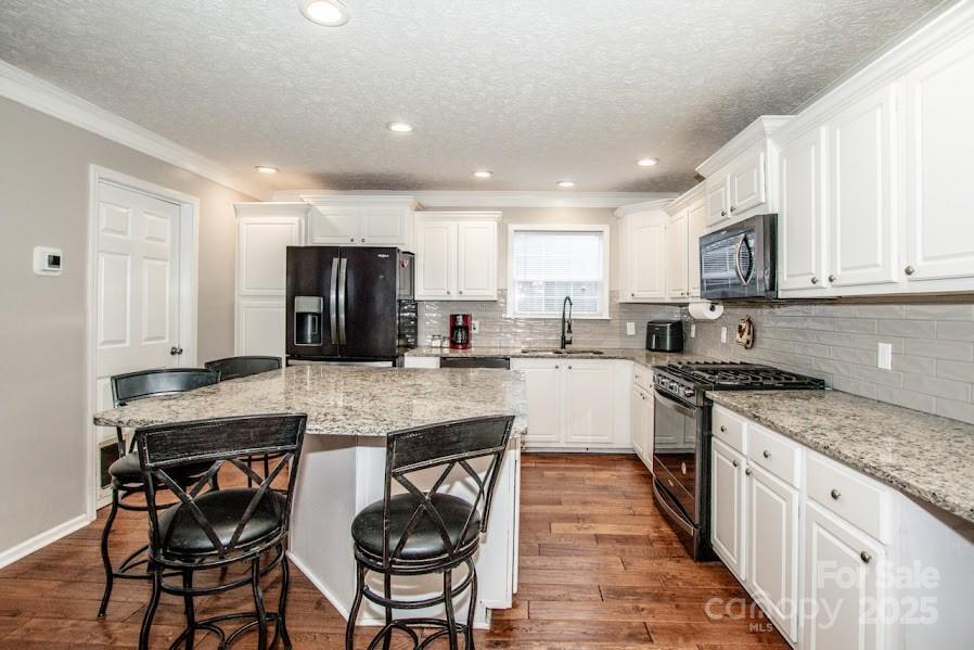 224 Stewart Rock Road Stony Point, NC 28678 - Photo 15 of 41 a kitchen with stainless steel appliances granite countertop wooden cabinets a stove a sink and a refrigerator